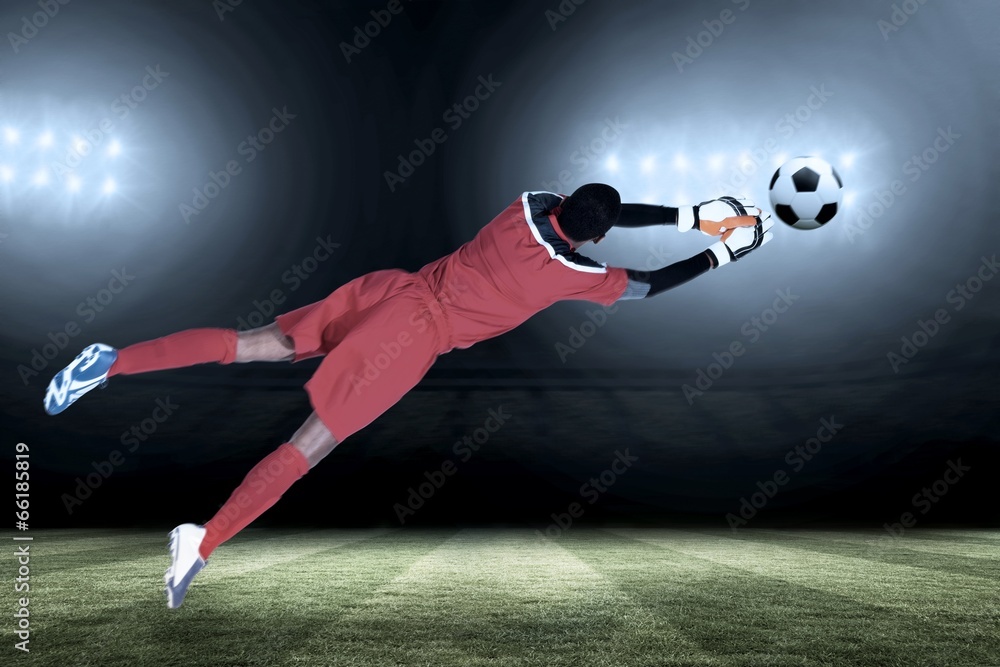 Fototapete composite image of goalkeeper in red making a save