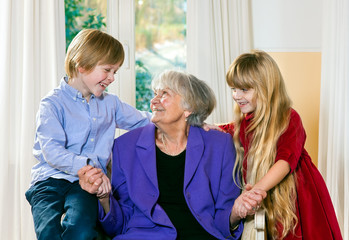 Loving little boy and girl with their grandmother.