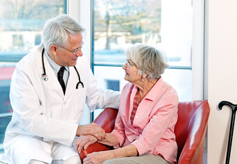 Friendly doctor reassuring an elderly woman.