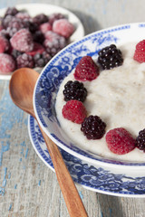 Breakfast porridge with frozen raspberries and blackberries.
