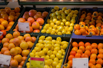 fresh orange lemon persimmon in plastic boxes