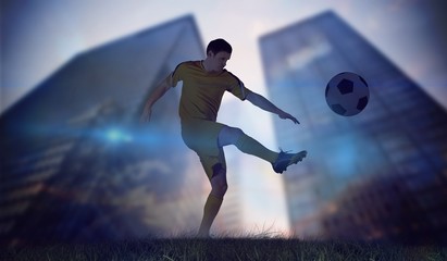 Fototapeta na wymiar Composite image of football player in yellow kicking