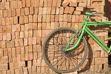 old used bicycle near red bricks stack, India