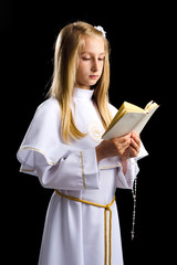 Girl reading Holy Bible for first communion