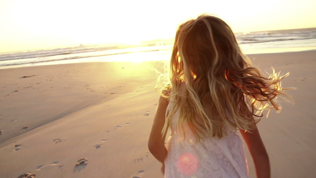 Little girl is running towards sunset