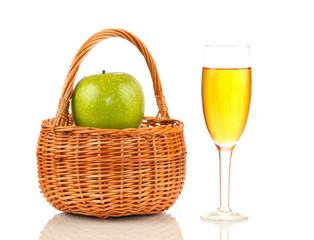 Crib with apples and glass of juice on white background