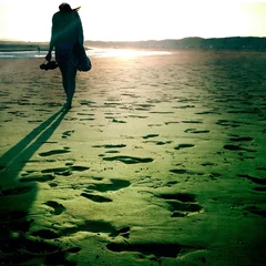 Foto op Canvas Silhouette of girl walking on the beach © Radek Sturgolewski