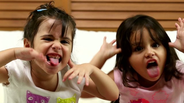 Small girls making a funny face in the bedroom