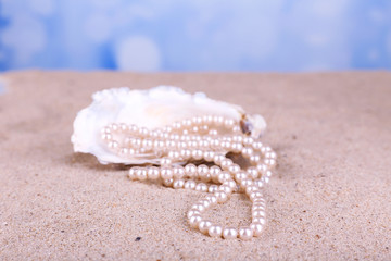 Fototapeta na wymiar Beautiful pearls in shell on sand, close up