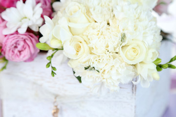 Beautiful wedding flowers in crate on bright background