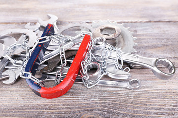 Magnet and wrenches on color wooden background