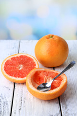 Ripe grapefruits on color wooden table, on light background