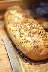 Baked bread with poppy and cutting knife.