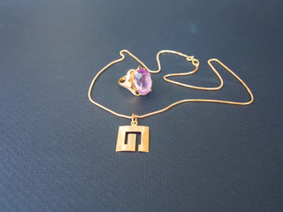 Fototapeta na wymiar Pendant on golden chain and ring with amethyst
