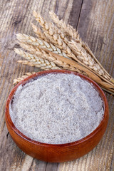 whole grain flour in a bowl on the old rustic table