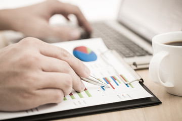 Businessman analyzing investment charts with laptop