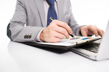 Businessman analyzing investment charts with laptop