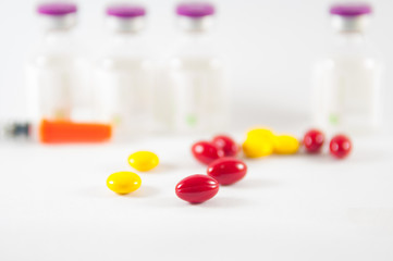 Red tablet on medicine vials background