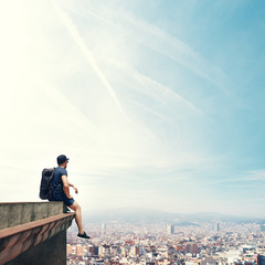 Young man sitting on a roof and looking city