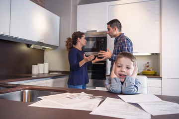 Sad child suffering and parents having discussion