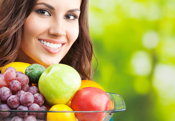 Woman with plate of fruits, outdoors