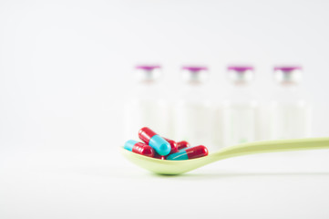 Red and Grey capsule in spoon show medicine concept