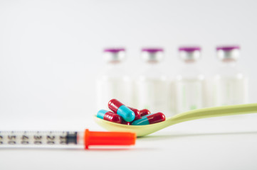 Red and Grey capsule in spoon and syringe show medicine concept