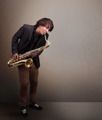 Naklejka premium Young musician playing on saxophone