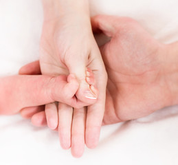 Hands of mother, father and newborn baby
