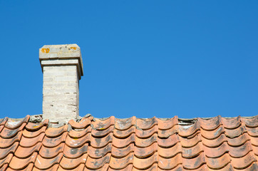 Chimney at an old broken tiled roof