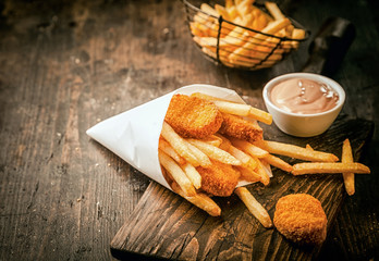 Crumbed fried fish nuggets with potato chips