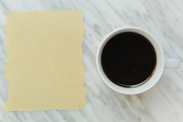 White coffee mug and raw paper on italian marble