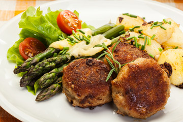 Meatballs served with boiled potatoes and asparagus