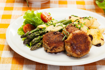 Meatballs served with boiled potatoes and asparagus