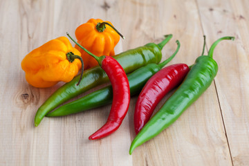 Mix of hottest peppers on wooden table
