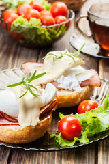 Eggs Benedict on toasted muffins with ham