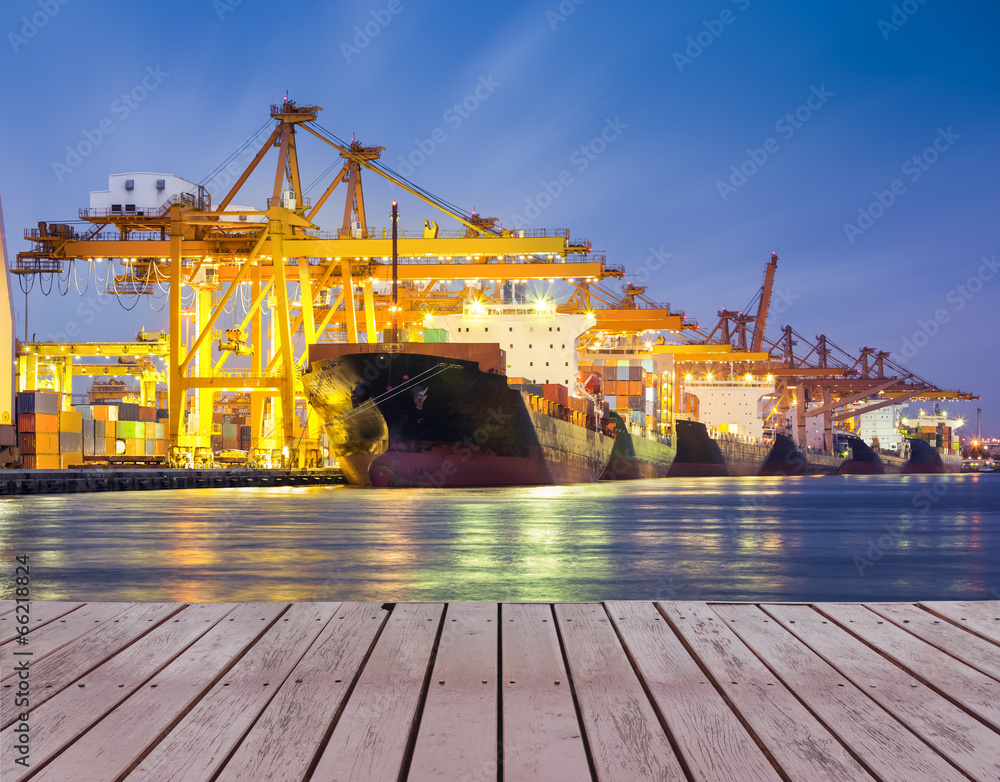 Wall mural gantry crane loading and unloading cargo container from cargo ship at port to show global internatio