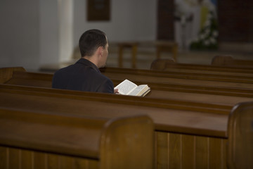 Man reading Bible in church