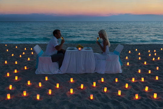 lovers couple share a romantic dinner on sea beach