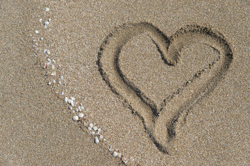 Fototapeta na wymiar Heart drawn at sand. Sea beach background. Top view.