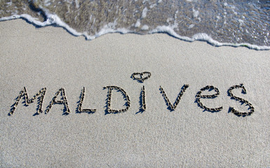 word Maldives outline on the sand