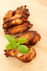 Deep dried chicken wings on a bamboo cutting board with basil le
