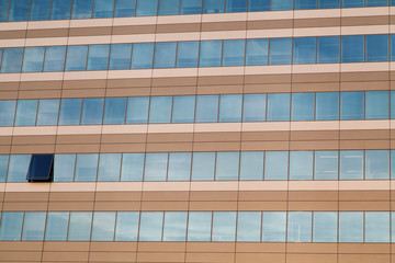 Row of office building windows in frames and one open