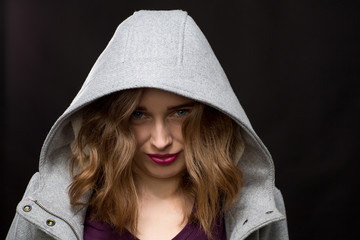 Coy or shy young woman wearing a hood