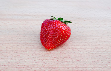 one strawberry on a board