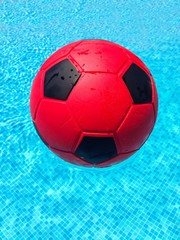 Fototapeta na wymiar Red football in a swimming pool