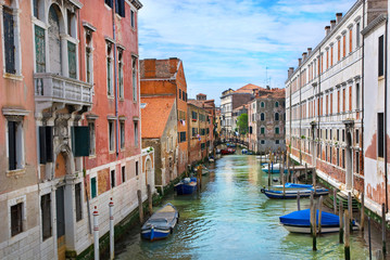 Fototapeta na wymiar Venice canal with gondolas, boats and small bridge. Italy