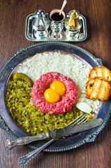 Fresh steak tartar with pickled cucumber and onion