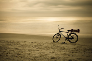Fototapeta premium Bicycle at the beach Sunrise Clouds
