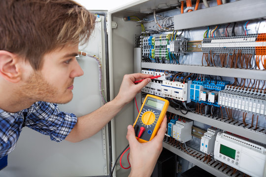 Technician Examining Fusebox With Insulation Resistance Tester